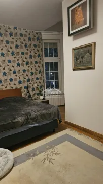 Spavaća soba sa bračnim krevetom, tapetama i slikama na zidu. - image 10