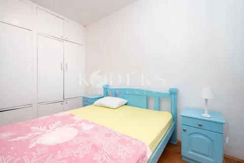 Bedroom with a blue bed, nightstand, and built-in wardrobe. - image 3