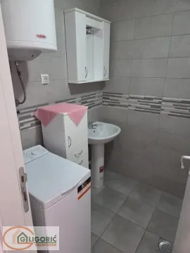 Bathroom equipped with a sink, cabinet, water heater, and washing machine. - image 12