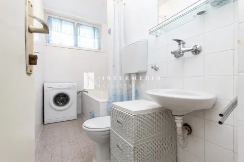 Manje kupatilo sa bijelim pločicama, umivaonikom, wc šoljom, kadom i mašinom za veš. - image 11