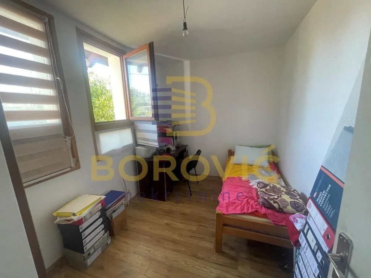 Manja spavaća soba sa krevetom i radnim stolom.