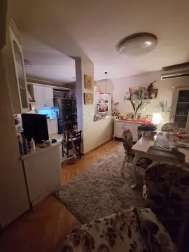 Dining and living area connected to a kitchen with warm lighting. - image 10