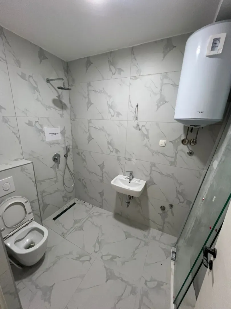 Kupatilo opremljeno tuš kabinom, umivaonikom, wc šoljom i bojlerom.