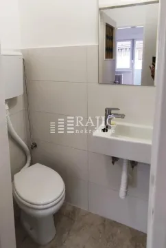 Small bathroom with toilet, washbasin, and mirror. - image 14