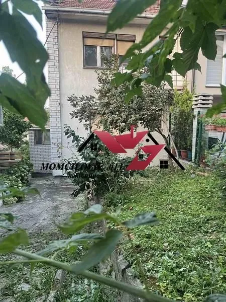 Pogled na dvorište i zadnju stranu kuće sa zelenilom.