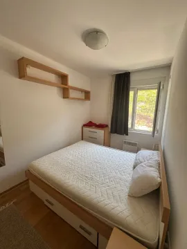 Small bedroom with a double bed, dresser, and a window. - image 2