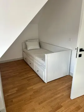 Manja spavaća soba sa bijelim krevetom i drvenim podom u potkrovlju. - image 9