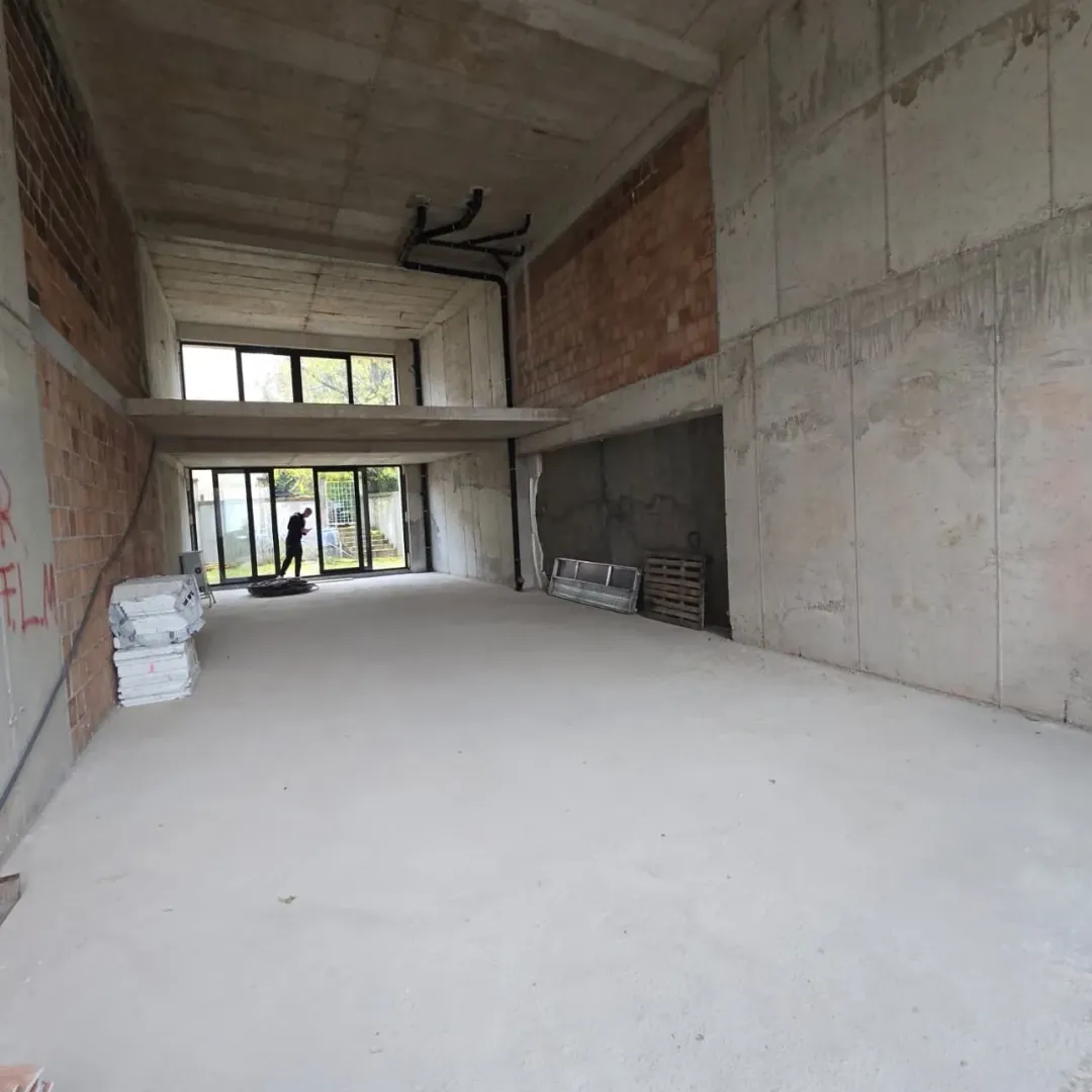 View of an unfinished space under construction with concrete walls and a gallery.