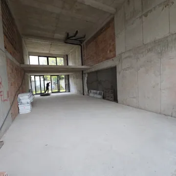 View of an unfinished space under construction with concrete walls and a gallery. - image 5