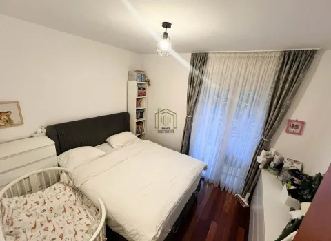 Bedroom with a double bed, baby crib, and balcony doors. - image 6