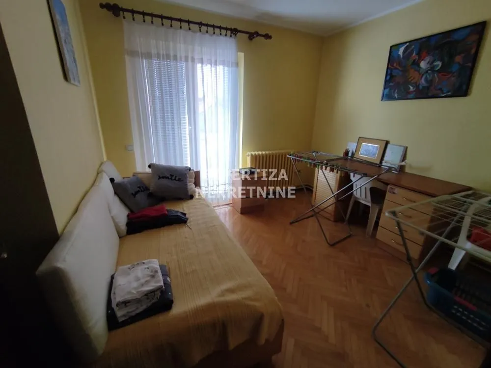 Smaller bedroom with a bed and a desk.