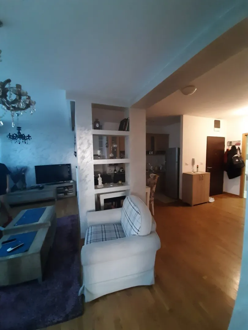 Living room with an armchair and open access to the kitchen.