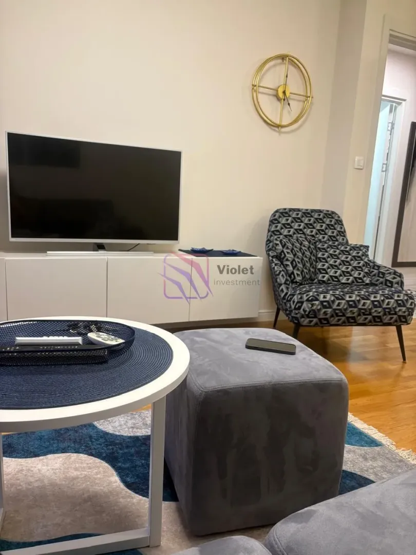 Part of the living room with a TV, armchair, and coffee table.