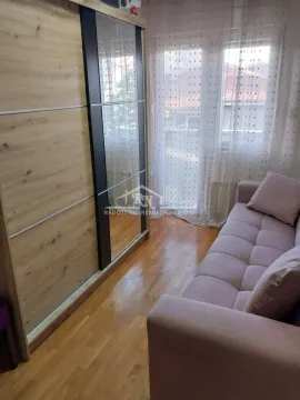 Dnevna soba sa kaučem, velikim garderoberom i prozorima. - image 11