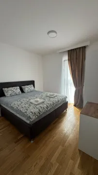 Uređena spavaća soba sa bračnim krevetom i drvenim podom. - image 5
