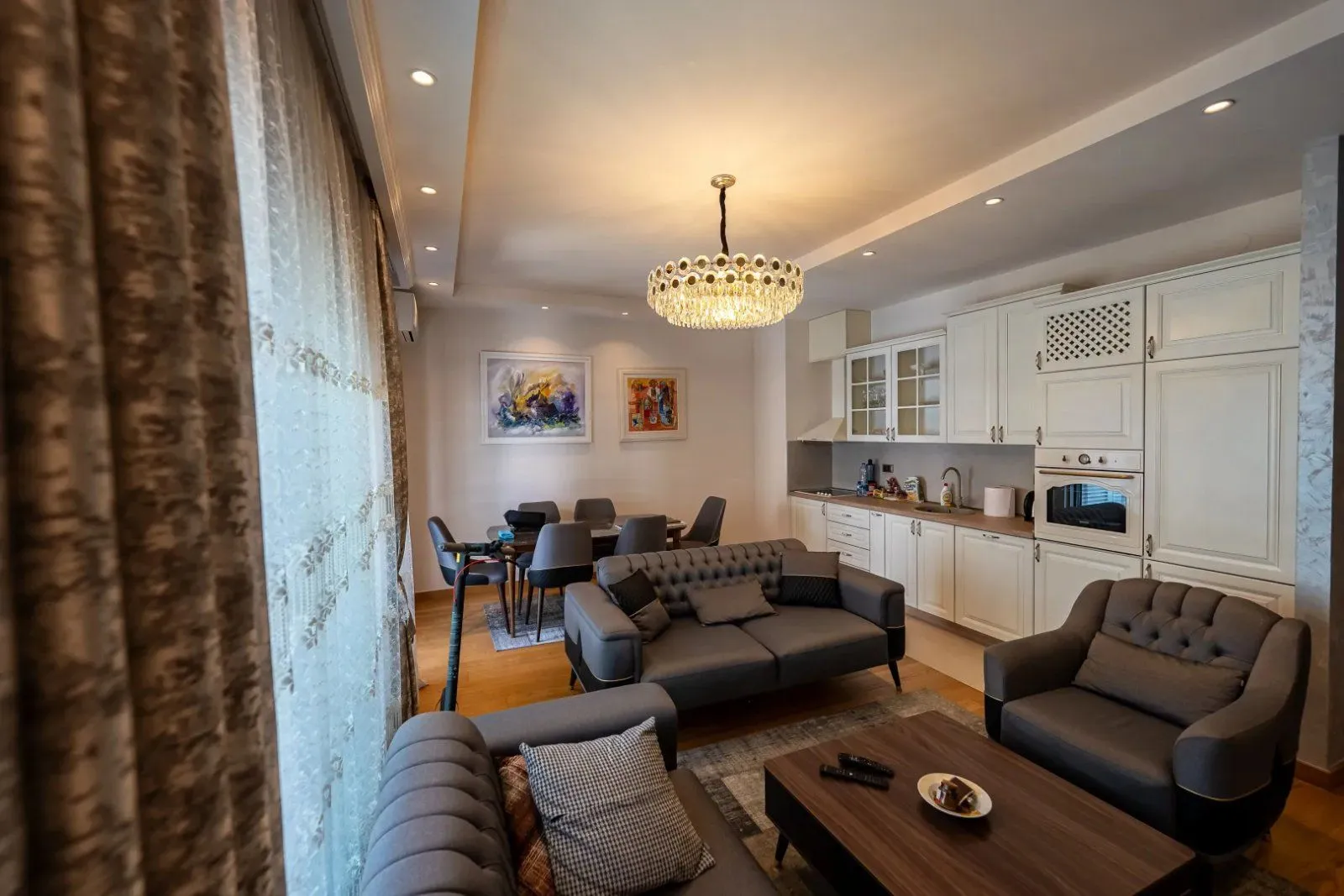 Spacious living room with a sofa set, dining area, and open kitchen.