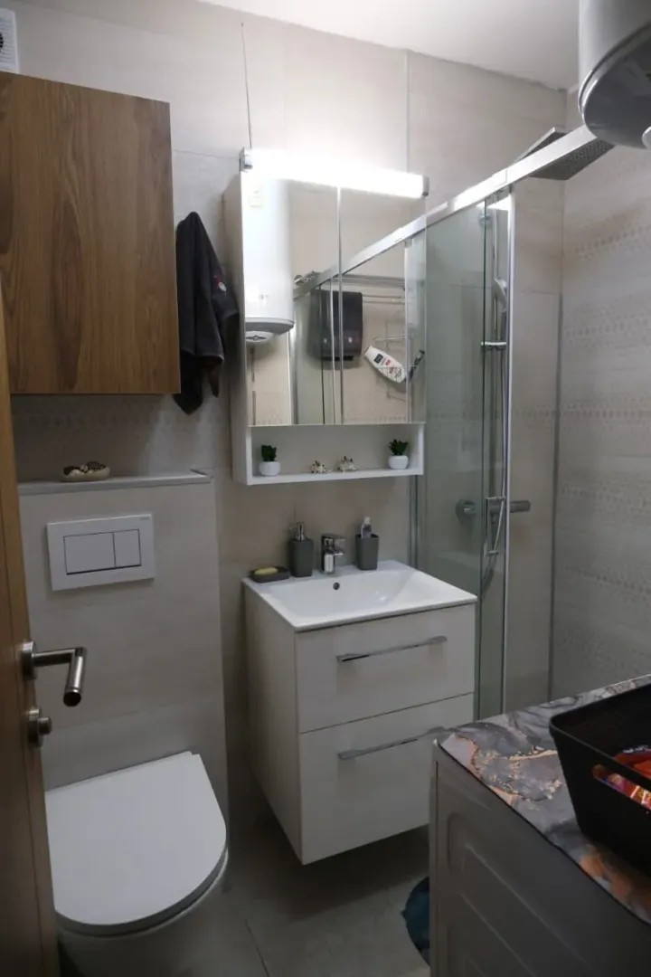 Modern bathroom with a shower cabin and sink vanity.