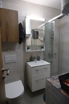 Modern bathroom with a shower cabin and sink vanity. - image 9