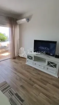 Dnevna soba sa televizorom, komodom i izlazom na terasu. - image 3