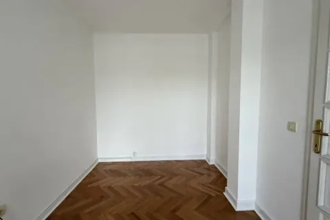 Prazna prostorija sa belim zidovima i parketom. - image 9