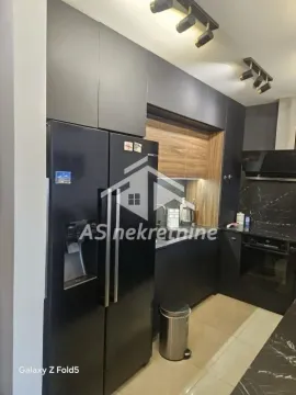 Modern dark-toned kitchen with built-in appliances and a large refrigerator. - image 7