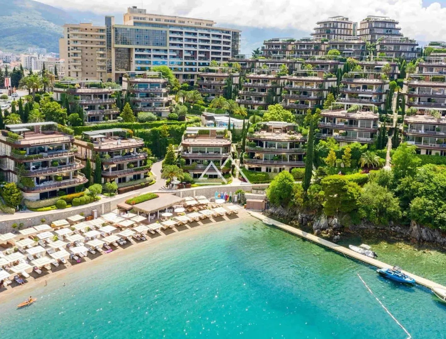 Pogled iz vazduha na hotelski kompleks sa plažom i zelenilom.