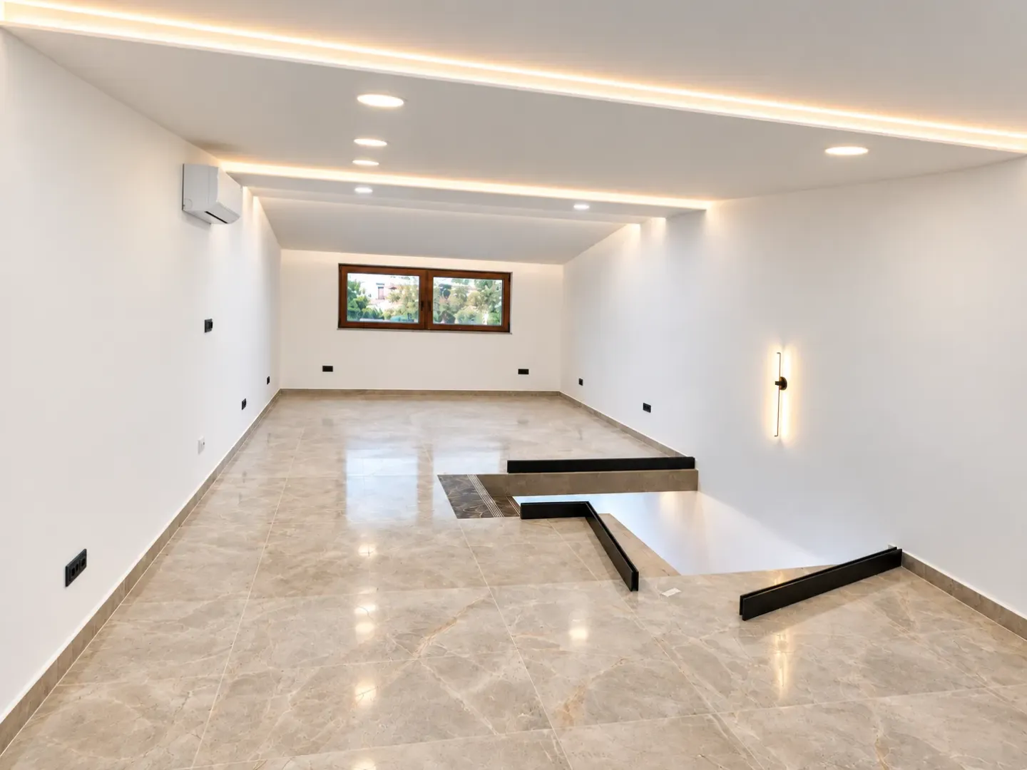 Empty spacious room with tiled flooring and recessed lighting.