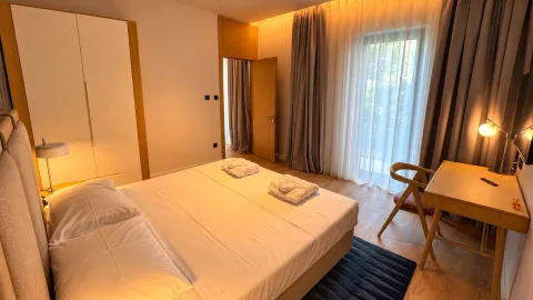 Moderna spavaća soba sa bračnim krevetom, garderoberom, radnim stolom i izlazom na terasu. - image 7