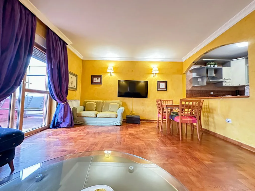 Living room with sofa, dining area, and access to the terrace.