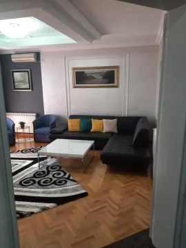 Living room with a sofa, coffee table and parquet flooring. - image 14