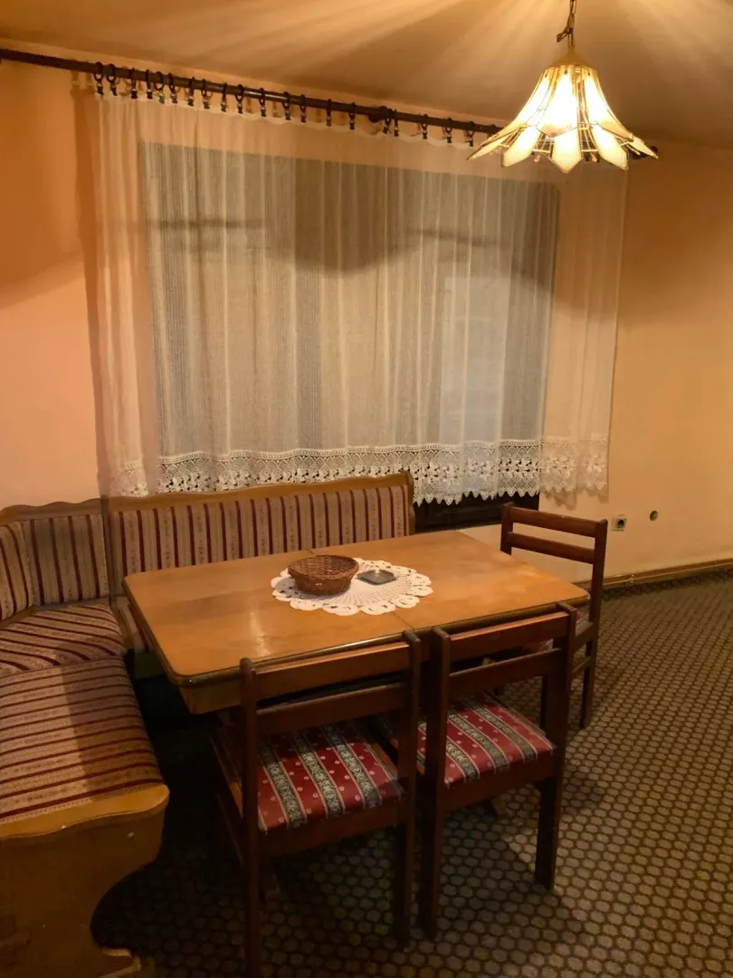 Trpezarija sa drvenim stolom, klupom i stolicama.