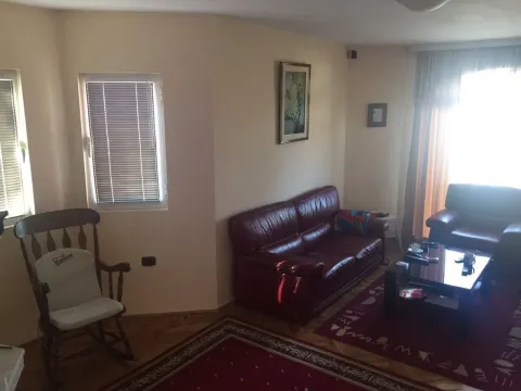 Living room featuring leather sofas, a wooden rocking chair, and red patterned carpets. - image 13