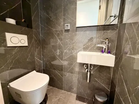 Small bathroom clad in dark marble with a basin and toilet. - image 17