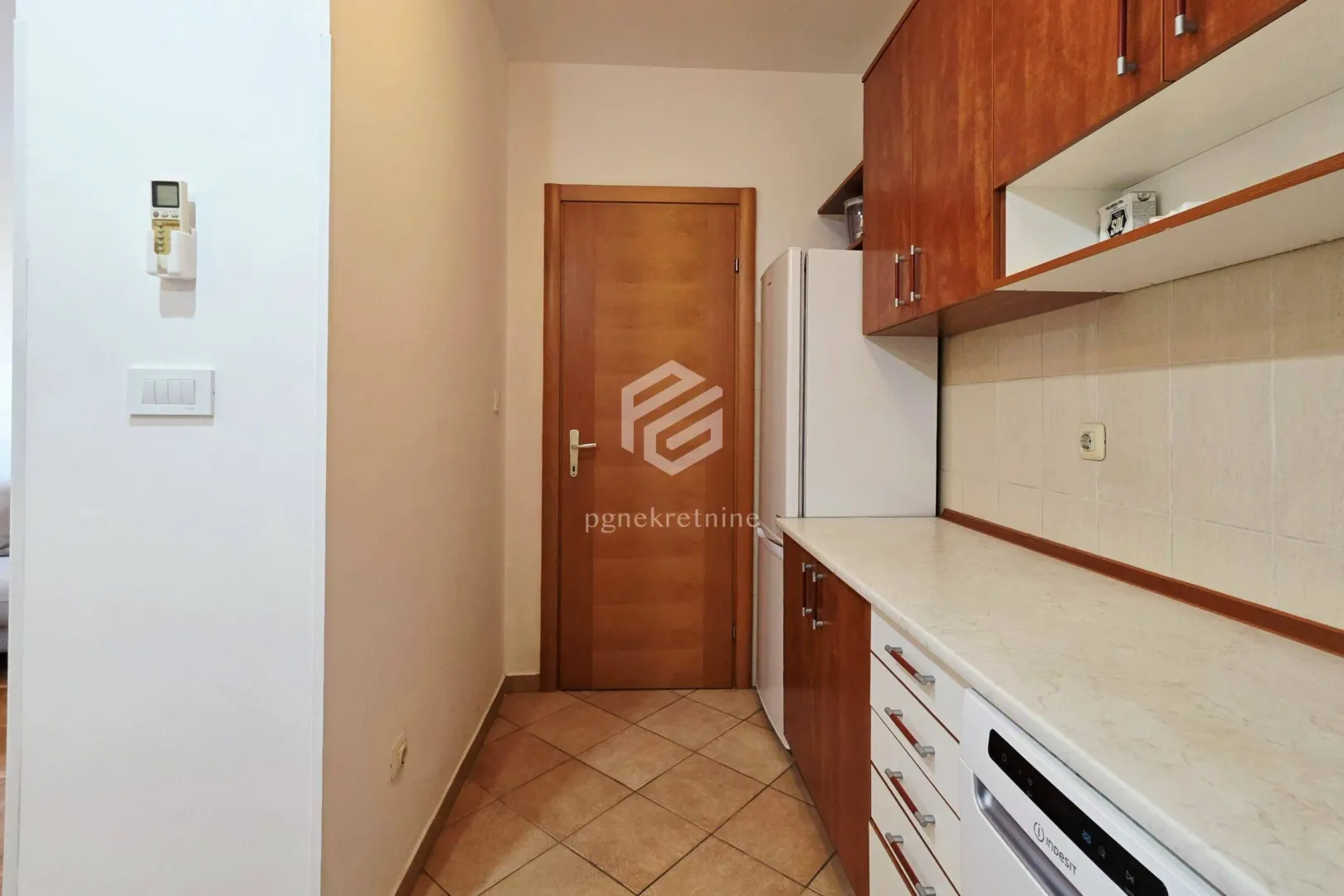 Smaller kitchen with wooden cabinets and appliances.