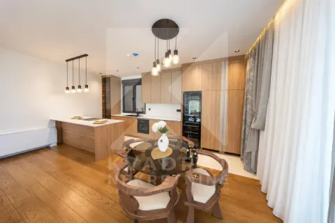 Modern kitchen with wooden elements, island, and dining table. - image 22