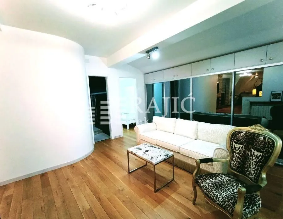 Living room with a sofa and hardwood flooring.