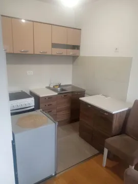 Smaller kitchen with brown tone elements and a stove. - image 14