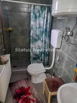 Manje kupatilo sa tuš kabinom obloženom sivim pločicama. - image 4
