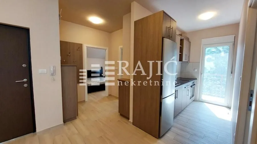 Hallway with a kitchen and a view of the apartment interior.