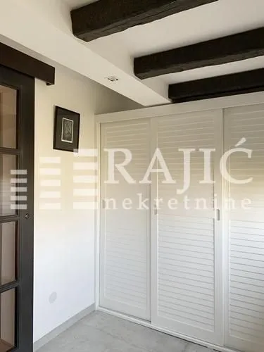 Bedroom with built-in wardrobe and wooden ceiling beams.