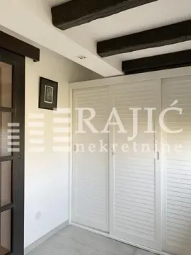 Bedroom with built-in wardrobe and wooden ceiling beams. - image 10