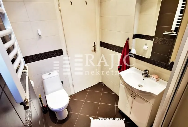Small bathroom with a sink, toilet, and mirror.