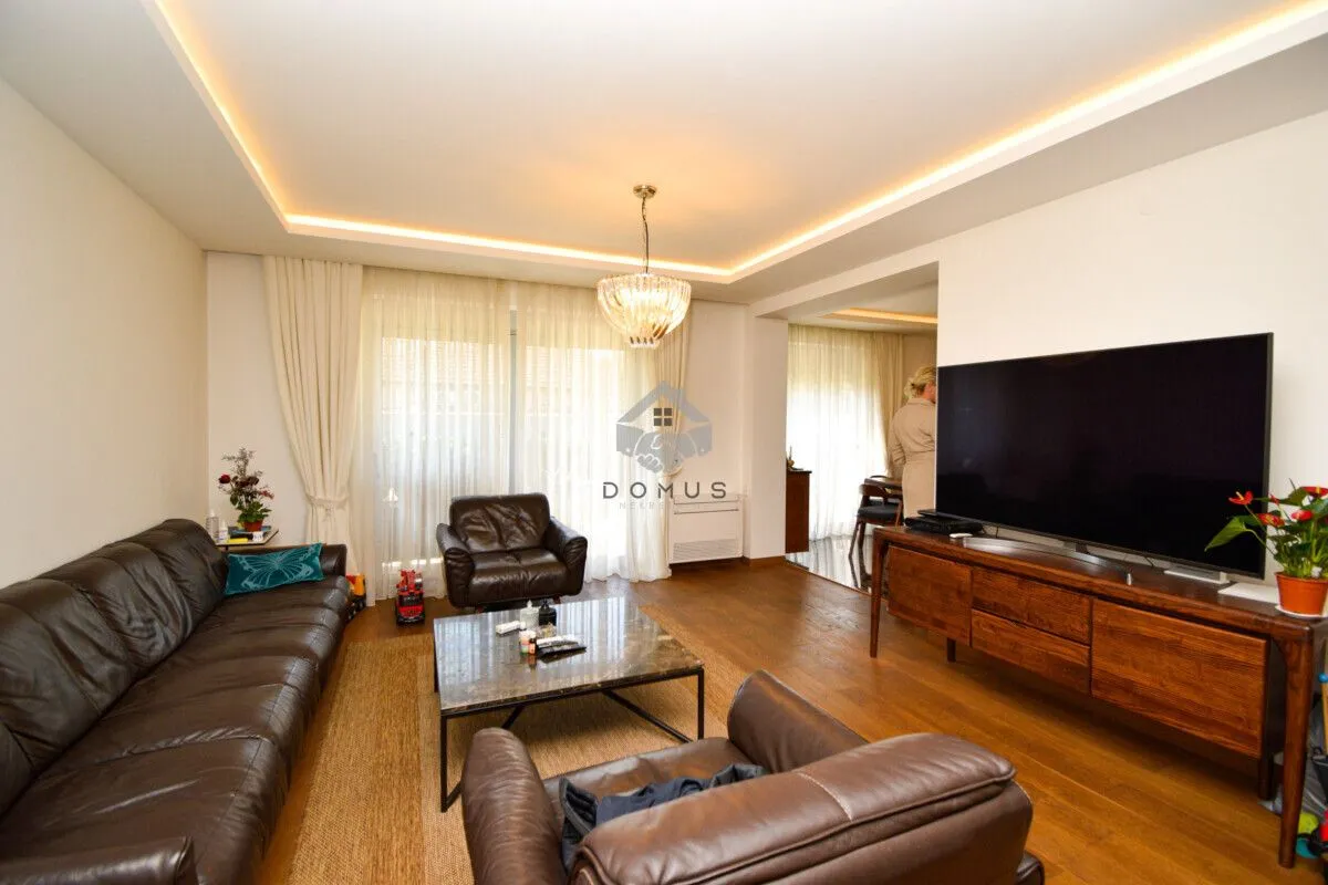 Spacious living room with leather sofas and a large television.