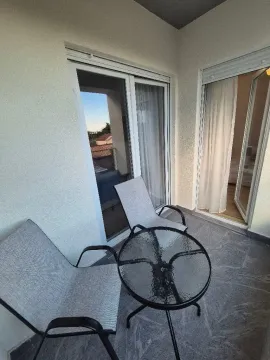 Namještena terasa sa stolom i dve stolice i pogledom na okolinu. - image 12