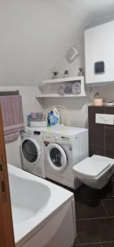 Kupatilo opremljeno kadom, toaletom i mašinama za pranje i sušenje veša. - image 19