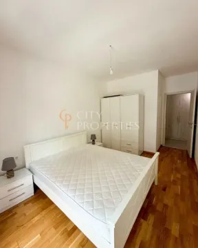Namještena spavaća soba sa bijelim krevetom, ormarom i drvenim podom. - image 7