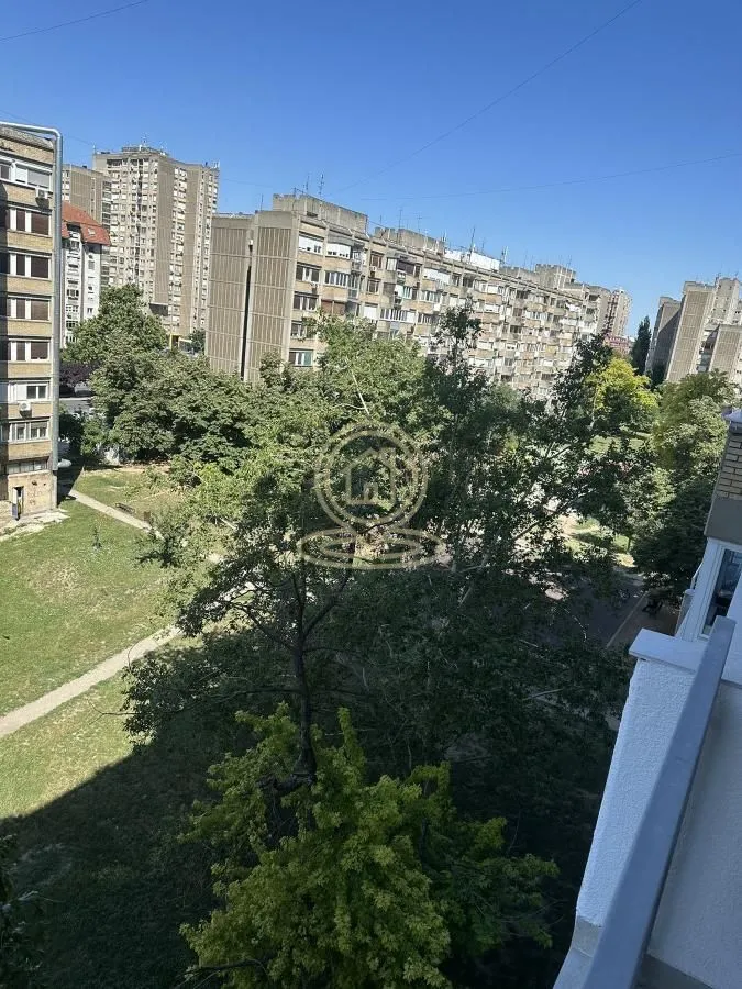 Pogled sa terase na okolne zgrade i zelene površine.
