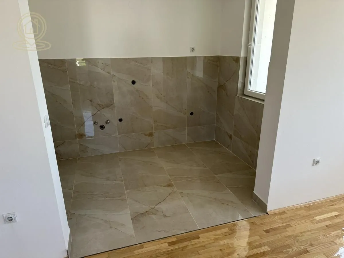 Unfurnished kitchen area with ceramic tiles and plumbing connections.