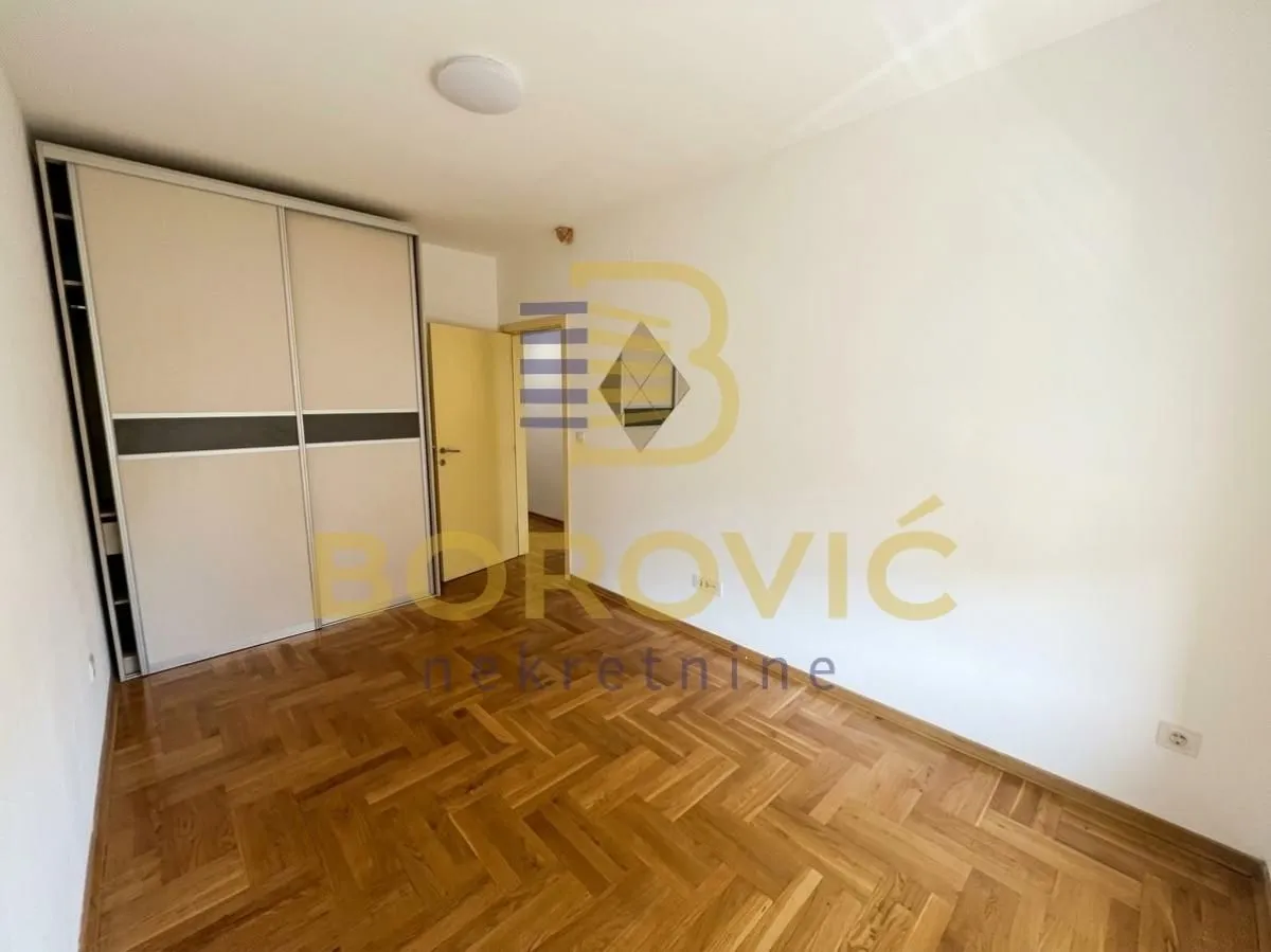 Smaller bedroom with a built-in wardrobe and parquet flooring.
