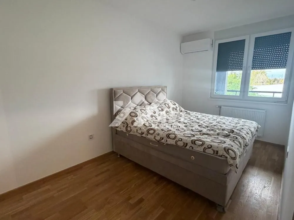 Furnished bedroom with a double bed and a window.
